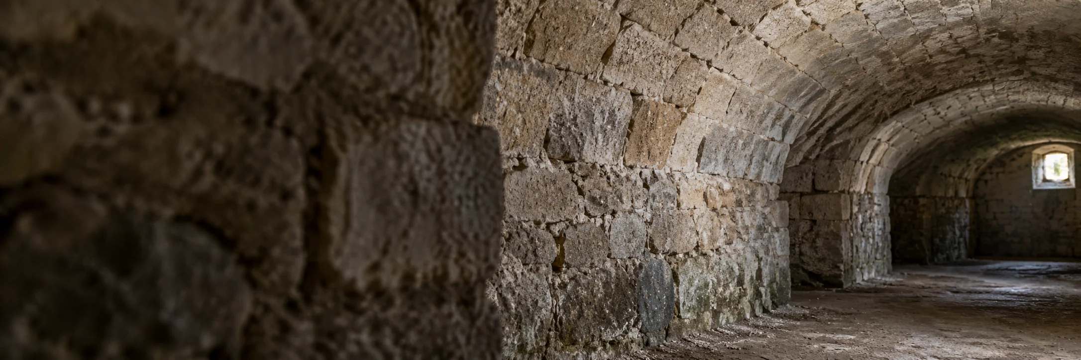 Voûte et naissance de voûte en maçonnerie de pierre dans une cave