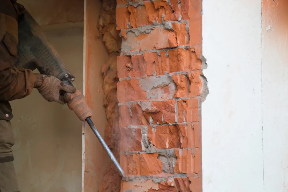 Dépose localisée d’une maçonnerie en briques avec un outil de chantier
