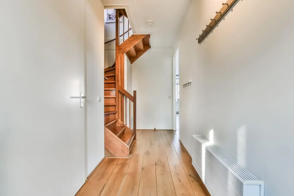 Examiner les contraintes de l’escalier existant Escalier en bois et passage dans le plancher au bout d’un couloir étroit
