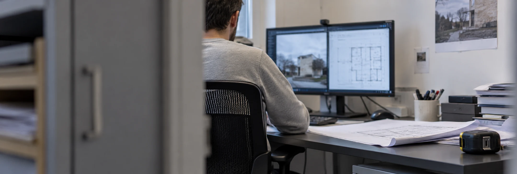 Étude de plans et de photographies d’un bâtiment sur un poste informatique