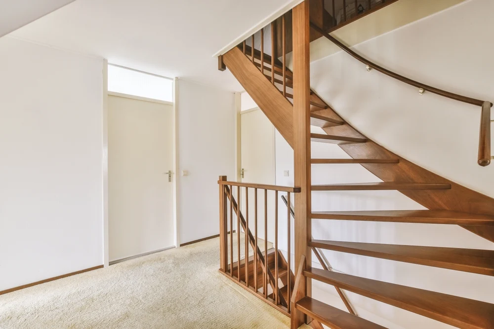 Escalier en bois traversant une ouverture du plancher dans un logement existant